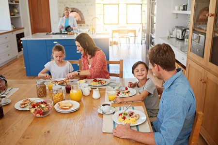 Photo for Food, morning and a family eating breakfast in the dining room of their home together from above. Mother, father and sibling children sitting at a table in their apartment for love or bonding. - Royalty Free Image