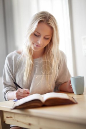 Photo for Coffee, relax and woman writing in a book at home for idea, planning or creative, research or diary. Notebook, education and female student in a house with tea while brainstorming homework assignment. - Royalty Free Image