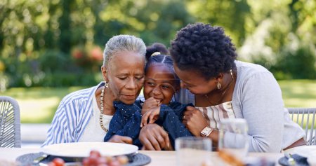 Foto de Abuela, madre e hija para abrazar en el jardín, sonrisa y almuerzo para relajarse junto con el amor. Gente negra, mujeres y niños como familia feliz, gratitud y cuidado de la unión para la mesa de almuerzo en el parque. - Imagen libre de derechos