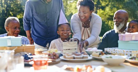 Young boy, birthday cake or family in garden for party, happy or gift in celebration in nature. Black people, smile and cream dessert with fun with bonding, excited and special kid event in backyard.