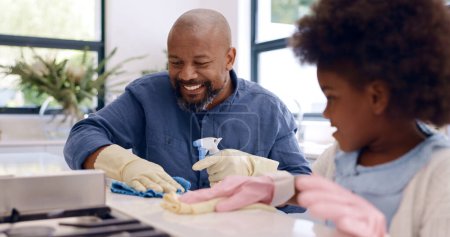 Photo for Father, daughter and cleaning with gloves in kitchen for bonding, happiness and teaching in home or house. Black family, man and girl child with cloth, liquid detergent and table with smile and care. - Royalty Free Image