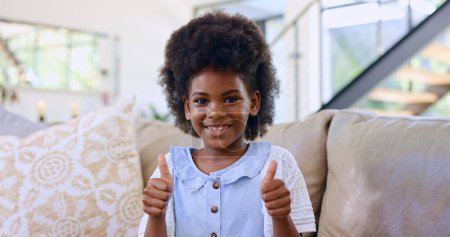 Photo for Home, portrait and black girl with thumbs up, smile and relax with support, agreement and feedback. African person, apartment or kid in a lounge, hand gesture and child with happiness, like or review. - Royalty Free Image