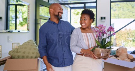 Photo for Couple, flowers and happy in new home or real estate with property investment, fresh start and support. Black people, man and woman with pot plant for moving, mortgage and excited for achievement. - Royalty Free Image