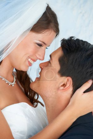 Téléchargez les photos : Visage, mariée et marié embrassent au mariage avec le sourire, l'amour et l'engagement pour le couple à la réception. Romance, homme et femme s'embrassant à la célébration du mariage avec bonheur, loyauté et avenir ensemble - en image libre de droit