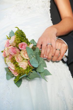 Photo for Couple, wedding ring and hands on rose bouquet in marriage with bride at celebration and event. Flower, loyalty and care with romance with love and commitment with woman and man and floral plant. - Royalty Free Image