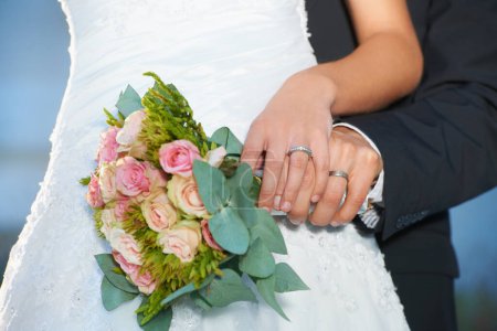 Photo for Couple, wedding ring and hands with bouquet in marriage with bride at celebration and trust event. Flower, loyalty and care with romance and jewelry with love and commitment with woman and man. - Royalty Free Image