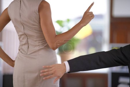 Foto de Hand, butt and sexual harassment with a business person slapping the behind of a woman coworker in the office. Ethics, behaviour or no with an employee reaching to smack the bottom of a colleague. - Imagen libre de derechos