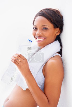 Foto de Mujer negra, fitness y botella de agua con retrato y sonrisa del deporte, entrenamiento y entrenamiento en estudio. Persona feliz, saludable y femenina con bienestar y bebida para gimnasio con fondo blanco. - Imagen libre de derechos