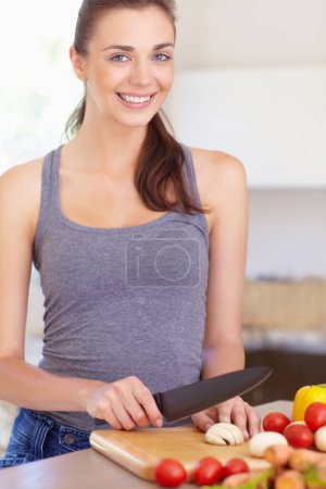 Photo for Woman, portrait and happy with knife or vegetables for nutrition, cooking or healthy meal in kitchen of home. Person, face and chopping board with mushroom, tomato and carrots for wellness and diet. - Royalty Free Image