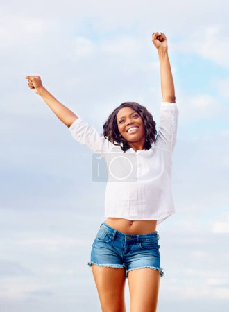 Téléchargez les photos : Femme noire, célébration et excité avec Voyage, vacances du gagnant heureux en vacances. Gagner, personne africaine et penser avec joie du ciel bleu, réalisation et liberté en plein air avec le sourire. - en image libre de droit