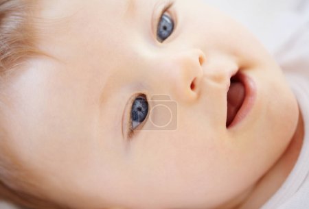 Photo for Home, bed and face of happy baby relax, rest and calm in nursery for sleeping or wake up in morning. Family, youth and closeup of infant newborn in bedroom for child development, growth and wellness. - Royalty Free Image
