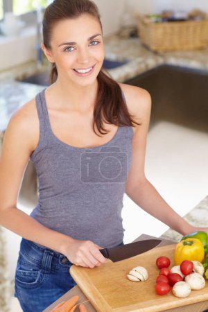 Photo for Woman, portrait and happy with knife or vegetables for nutrition, cooking or healthy meal in kitchen of home. Person, face and chopping board with mushroom, peppers and tomato for wellness and diet. - Royalty Free Image