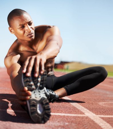 Photo for Man, training and stretching leg on ground, outdoors and fitness for health, sports and performance. Black male person, athlete and warmup on track, workout and commitment or ready, floor and cardio. - Royalty Free Image
