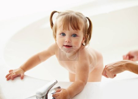 Photo for Portrait, cleaning and water with a baby in the bath for childhood hygiene or natural skincare. Children, bathroom and a happy young toddler girl in a bathtub for health and wellness in her home. - Royalty Free Image