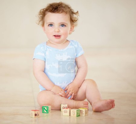 Photo for Baby, boy and blocks for building, floor and smile with development, learning or playful in family home. Infant child, toys and education for progress, growth or childhood with sitting, room or house. - Royalty Free Image