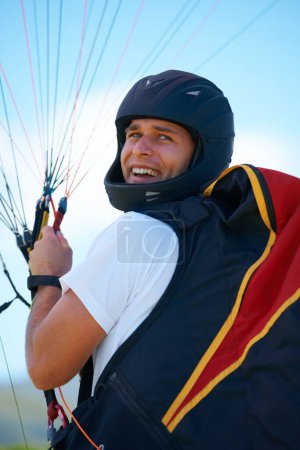 Photo for Man, parachute or launch in nature for sport, happy or exercise for healthy adventure for extreme fitness. Person, strings or smile for outdoor fun in wellness, helmet or safety gear in countryside. - Royalty Free Image