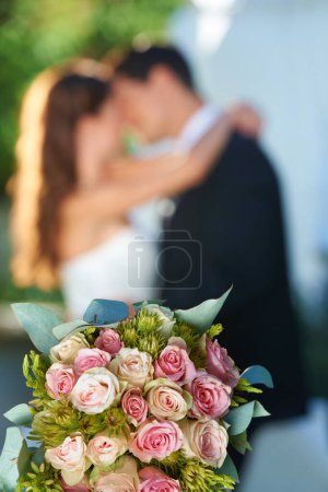 Téléchargez les photos : Bouquet, couple heureux et embrasser au mariage avec amour, sourire et engagement à l'événement de réception. Roses, femme et homme embrassant à la célébration du mariage fleurs, partenariat et avenir ensemble - en image libre de droit