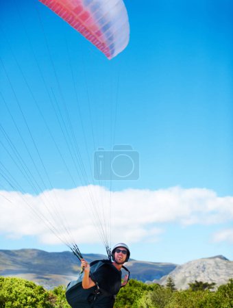 Photo for Man, parachute or paragliding sport in preparation exercise, healthy adventure or extreme fitness. Person, launch or fearless for outdoor flight in health wellness, helmet or safety gear by blue sky. - Royalty Free Image