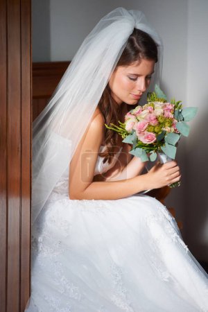 Photo for Bride, woman and smelling a bouquet at wedding, ceremony or event for aroma, scent and happy in dress. Marriage, person and flowers or roses for commitment, love and new beginning with smile or joy. - Royalty Free Image