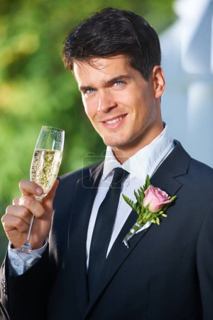 Foto de Feliz hombre, retrato y copa de champán en la boda del novio en brindis, celebración o discurso en la ceremonia al aire libre. Cara de hombre guapo, atractivo o casado con alcohol o bebida espumosa. - Imagen libre de derechos