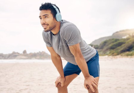 Photo for Fitness, headphones and portrait of man on beach running for race, marathon or competition training. Sports, workout and young male athlete listen to music, radio or playlist for exercise by ocean - Royalty Free Image