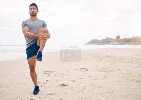 Téléchargez les photos : Fitness, étirement et espace avec un homme sur la plage au début de son entraînement pour la santé ou le bien-être. Exercice, réflexion et échauffement avec un jeune athlète s'entraînant en plein air au bord de l'océan ou de la mer. - en image libre de droit