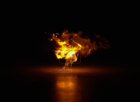 Foto de Explosión de llama, calor y fuego con fondo negro con chispas, gas y luz de la quema en el estudio. Combustible, fulgor y resplandor de la energía térmica n oscuro con creatividad e infierno con peligro. - Imagen libre de derechos