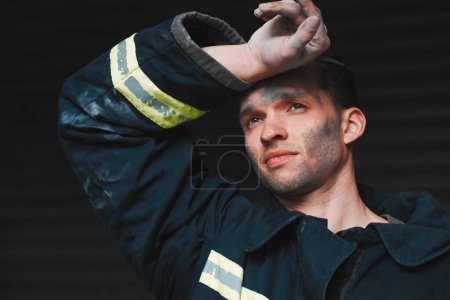 Photo for Firefighter, tired and man thinking of job on a black background with fatigue. Mexican male person, exhausted and fireman with future vision for rescue trouble and stress in a professional uniform. - Royalty Free Image