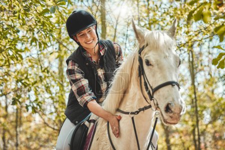 Téléchargez les photos : Portrait de femme heureuse à cheval, chevauchant dans les bois et pratiquant pour la compétition, la course ou le dressage avec des arbres. Sport équestre, jockey ou cavalier en forêt pour l'aventure, l'entraînement et le sourire - en image libre de droit