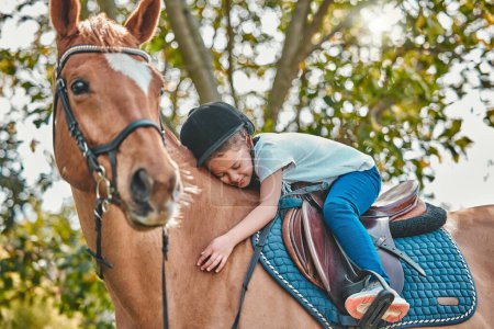 Photo for Love, nature and child hugging a horse in a forest riding for entertainment, fun or hobby activity. Adventure, animal and young equestrian girl kid embracing her stallion pet outdoor in the woods - Royalty Free Image