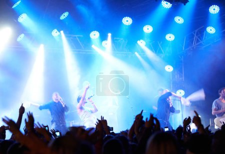 Photo for Concert crowd, music festival lights or band audience listen rock, metal or celebrity star, artist or stage performance. Night show energy, excited group celebrate and fans cheers for musician singer. - Royalty Free Image