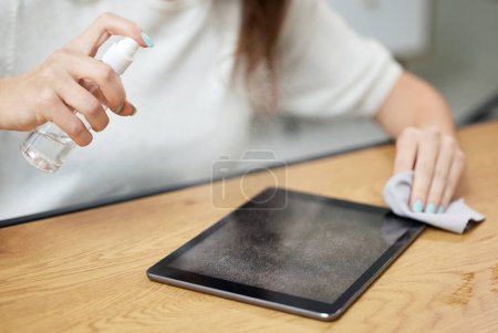 Photo for Hand, spray tablet and cleaning for screen, dust and dirt with shine on glass, hygiene and cloth in home. Woman, digital touchscreen and fabric, chemical and sanitation for bacteria, virus or health. - Royalty Free Image