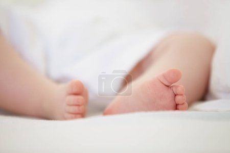 Photo for Sleeping, bed and feet of baby in home for dreaming, resting and nap for child development. Family, nursery and closeup of toes of newborn infant in bedroom relax for wellness, health and growth. - Royalty Free Image