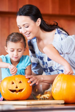 Photo for Halloween, pumpkin and mother with child in the kitchen for holiday celebration at home. Creative, smile and happy mom with girl kid bonding and carving vegetable for decoration or tradition at house. - Royalty Free Image