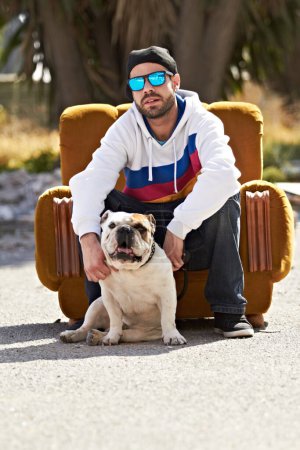 Photo for Couch, city and portrait of man with dog in street for urban fashion, casual style and trendy outfit. sunglasses, pets and person on sofa in road with canine, bulldog and best friend for relaxing. - Royalty Free Image