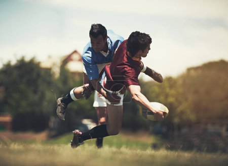 Foto de Hombres de rugby, tackle y fitness en un campo para deportes, pelota o acción, juego o poder al aire libre. Saltar, balonmano y equipo masculino en un parque para competitivos, entrenamiento o energía, entrenamiento o desafío activo. - Imagen libre de derechos