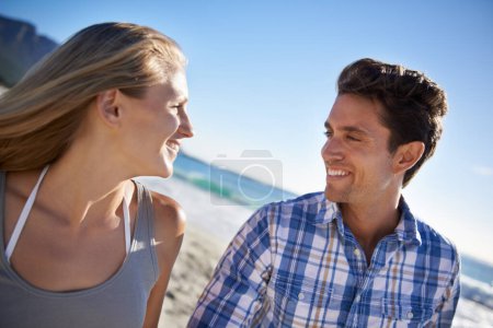 Photo for Couple, walk and smile on beach, talk and outdoor in summer sunshine for vacation, thinking or travel. Man, woman and happy with love, bonding and holiday by ocean for adventure in Naples, Italy. - Royalty Free Image