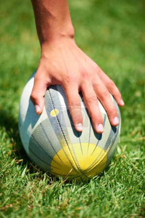 Photo for Closeup, rugby and leg with a ball of a player to kick for fitness training on a grass field. Man, uniform and sports exercise for healthy green lawn and active athlete playing for health. - Royalty Free Image