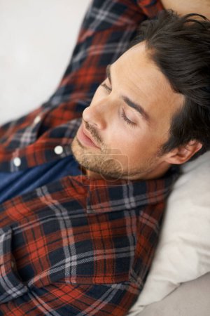 Photo for Relax, sleeping and man on sofa in home for afternoon nap, resting and calm in living room. Asleep, eyes closed and face closeup of tired person on couch lying for fatigue, comfortable and wellness. - Royalty Free Image