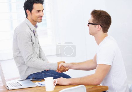 Photo for Business men, handshake and agreement at desk in office to offer promotion, support deal and success in creative agency. Team shaking hands for negotiation, onboarding or trust for design partnership. - Royalty Free Image