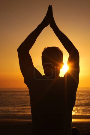 Téléchargez les photos : Silhouette, homme et prier avec les mains pour le yoga, la santé et le bien-être sur la plage avec coucher de soleil et zen. Personne, ombre et pilates ou namaste pour l'équilibre, la pleine conscience et le corps sain par l'océan ou la mer. - en image libre de droit