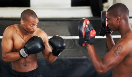 Photo for Boxing, coaching and black man with personal trainer for fitness, power or training challenge. Strong body, sparring partner and boxer in gym with fist up, workout and confidence in competition fight. - Royalty Free Image