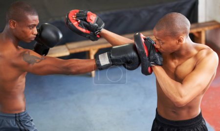 Photo for Fighting, coaching and boxer with personal trainer for workout, power or training challenge. Strong body, spar partner and black man in gym with fist up, fitness and confidence in competition boxing - Royalty Free Image