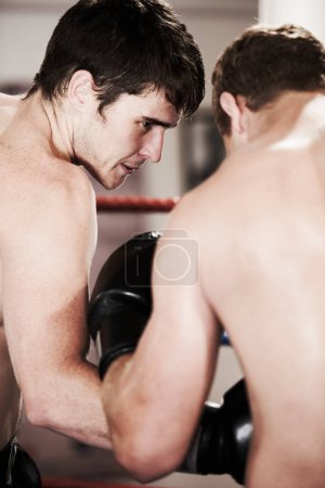 Photo for Man, boxing and fight in ring at gym for workout, exercise or indoor self defense training together. Male person, boxer or sports trainer fighting with sparing partner in competition or practice. - Royalty Free Image