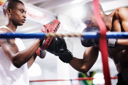 Photo for Man, boxing and personal trainer in ring fight at gym for workout, exercise or indoor self defense training together. Male person, boxer or fighting sparing partner in sports, competition or practice. - Royalty Free Image