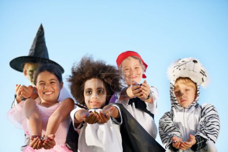 Photo for Children, hands and portrait for halloween costume for sweet candy asking, trick or treat for fantasy. Friends, group and dress up as witch or pirate for holiday, kid development on sky background. - Royalty Free Image
