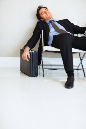 Photo for Business man, sleeping and case in lobby, chair and fatigue from travel, overworked or burnout in suit. Entrepreneur, briefcase and tired with rest, exhausted or luggage for corporate job with stress. - Royalty Free Image