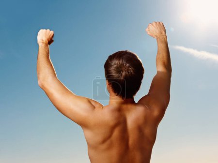 Téléchargez les photos : Dos, les mains levées et un homme torse nu sur un ciel bleu avec une fusée éclairante pour l'air frais en été pendant les vacances. Liberté, fitness et gagnant avec le corps d'une personne forte et en bonne santé en plein air pour le bien-être. - en image libre de droit