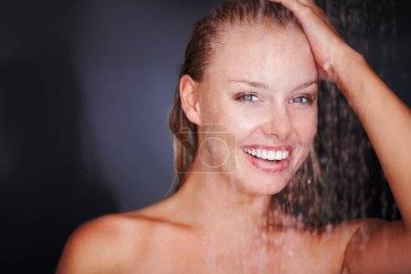 Photo for Shower, woman and water drops in studio portrait for skincare or wellness with happy in mockup. Young model, smile or face in natural glow of cleaning body or self care for beauty by black background. - Royalty Free Image