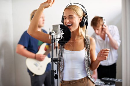 Photo for Professional, musician and happy woman with microphone, headphones and band performance with talent. Recording studio, art and girl singer live streaming for music label, sound and audio broadcast - Royalty Free Image